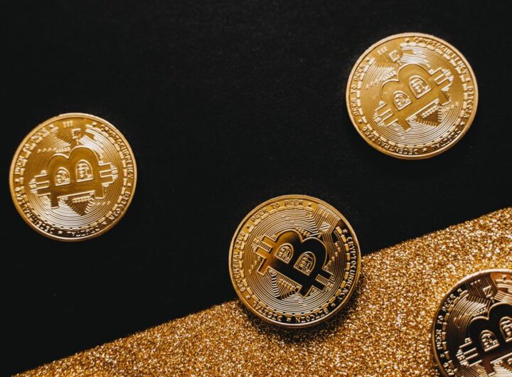 Stylish arrangement of golden Bitcoin coins on a sparkling gold glitter and black background.