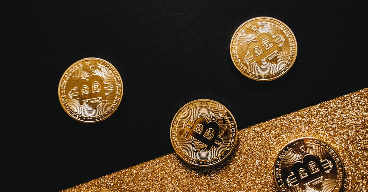 Stylish arrangement of golden Bitcoin coins on a sparkling gold glitter and black background.